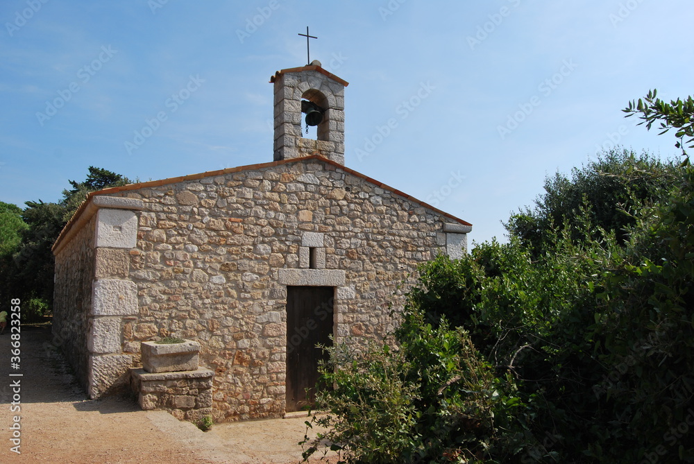 
small stone chapel with bell on the roof