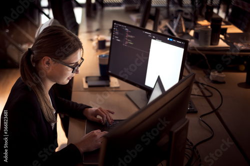 Girl with glasses in business clothes. Works on the computer.