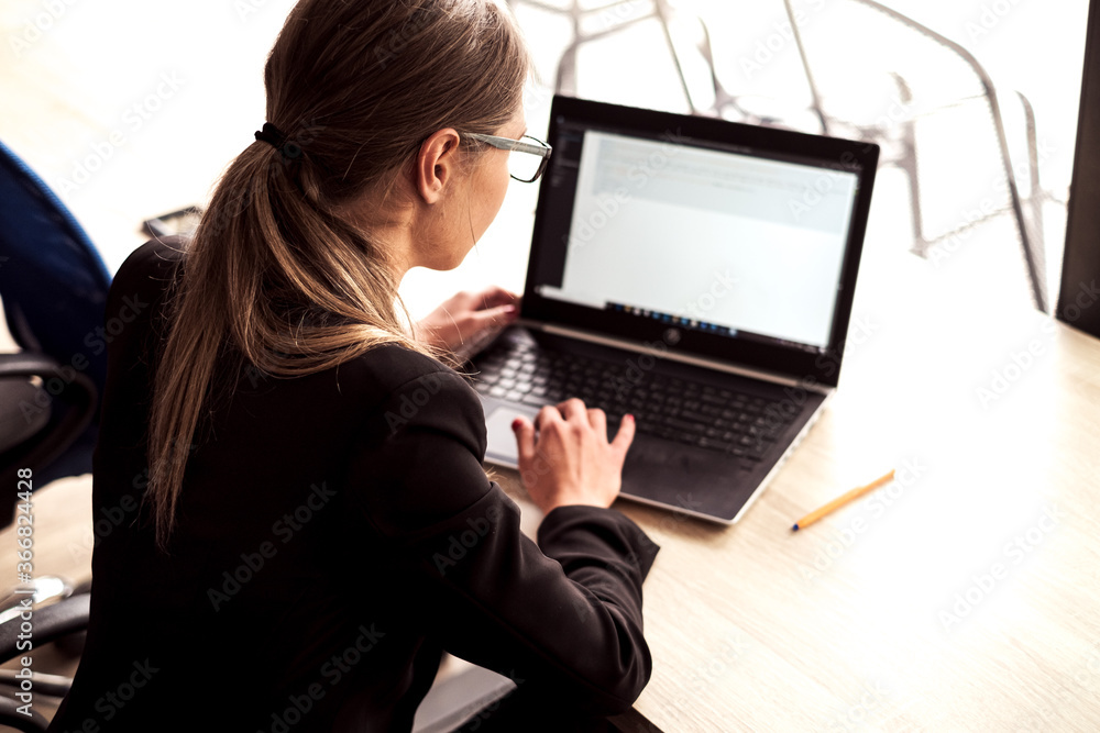 Girl with glasses in business clothes. Works on the computer. Girl with glasses in business clothes. Works on the computer.
