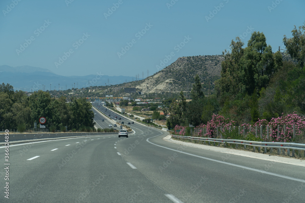 Driving in highway with low traffic and toll station in the background