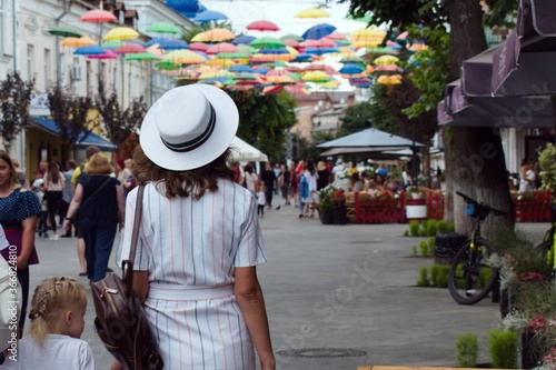girl in a white hat on a city street view from the back