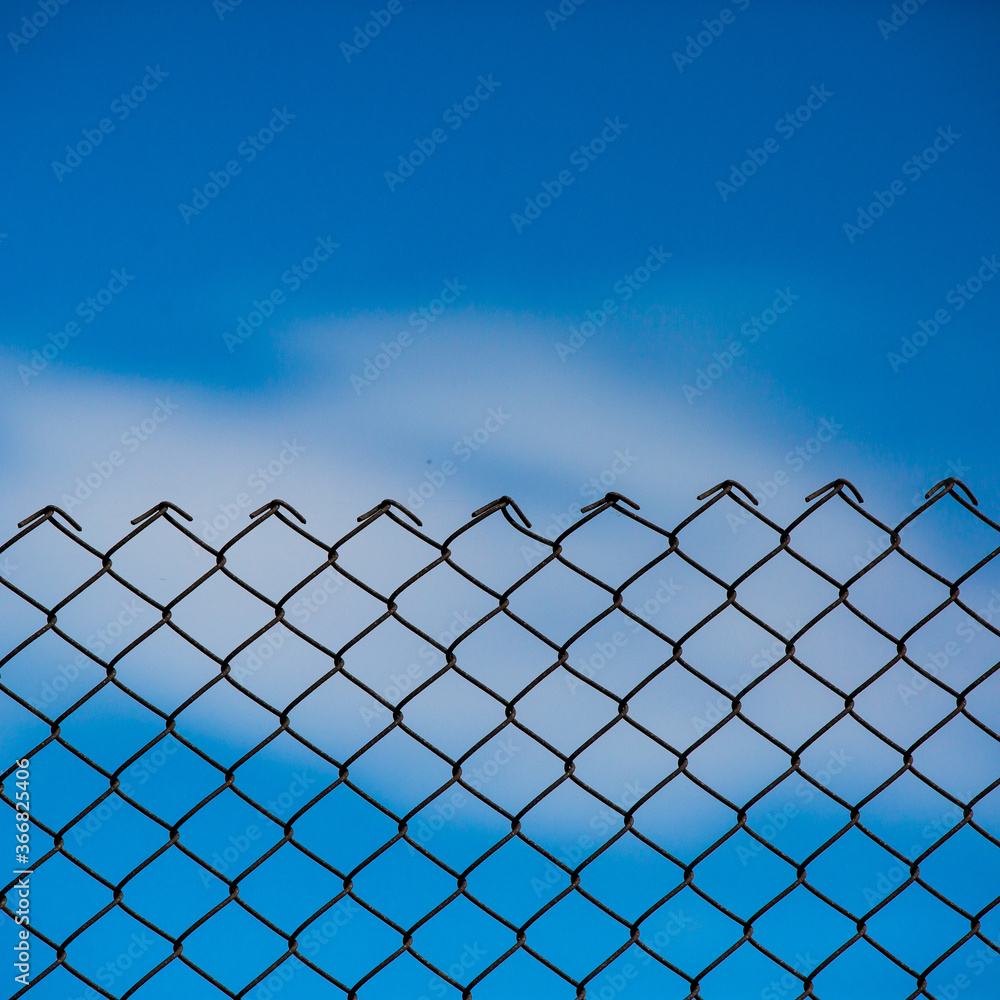 Wire fence and blue sky background Wire fence and blue sky background