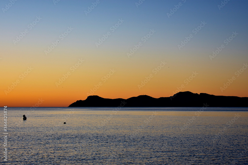 Sunrise over palma de port de pollensa beach in Mallorca, Spain with jetty / pier 