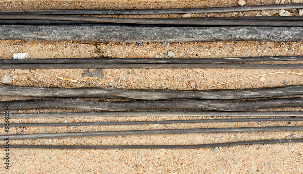 wires of different thickness lie on the sand with stones 