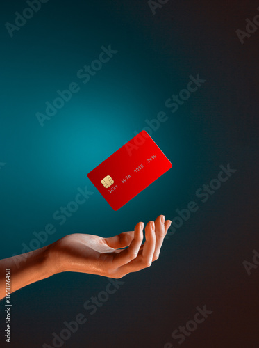 Close up female hand holds levitating template mockup Bank credit card with online service isolated on blue background
