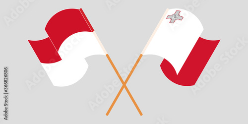 Crossed and waving flags of Malta and Indonesia