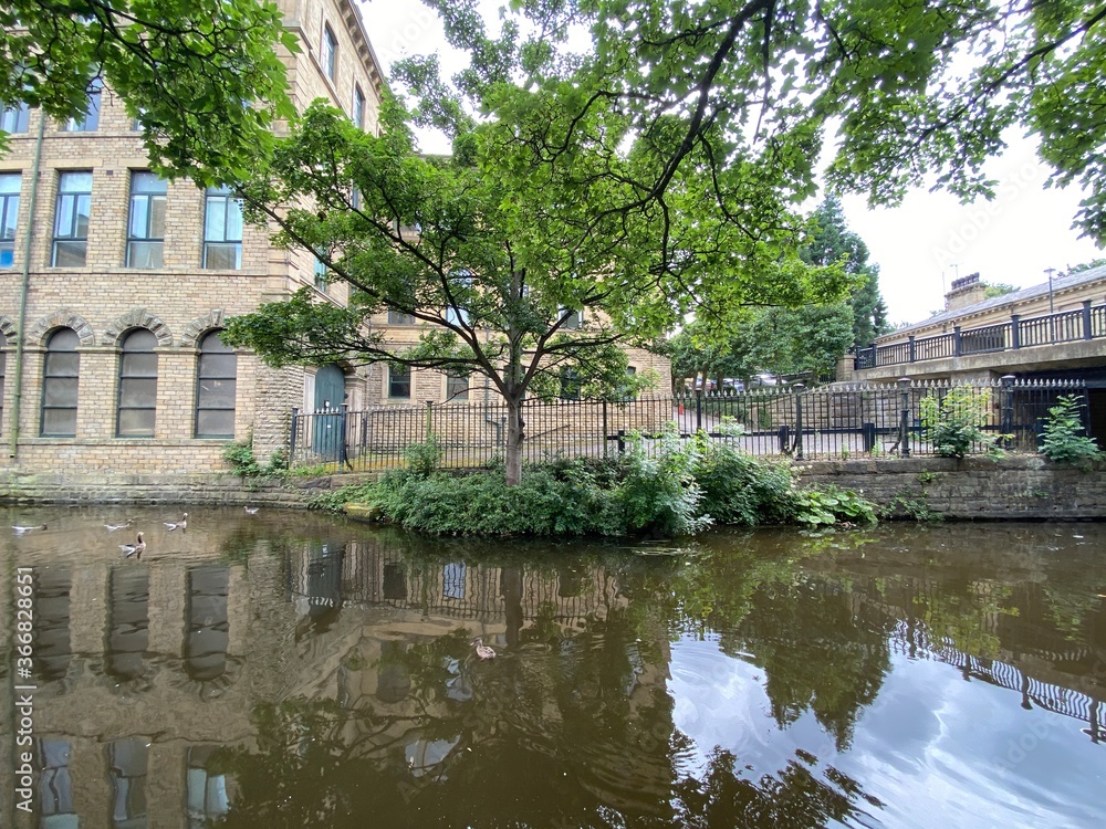 A view across the Leeds to Liverpool canal, of the Victorian mills and buildings in, Saltaire, Bradford, UK A view across the Leeds to Liverpool canal, of the Victorian mills and buildings in, Saltaire, Bradford, UK