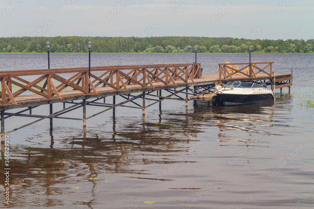 A small motor boat at the pier on the Volga river. The boat is on the water.