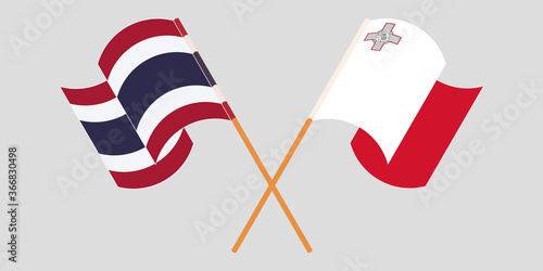 Crossed and waving flags of Malta and Thailand