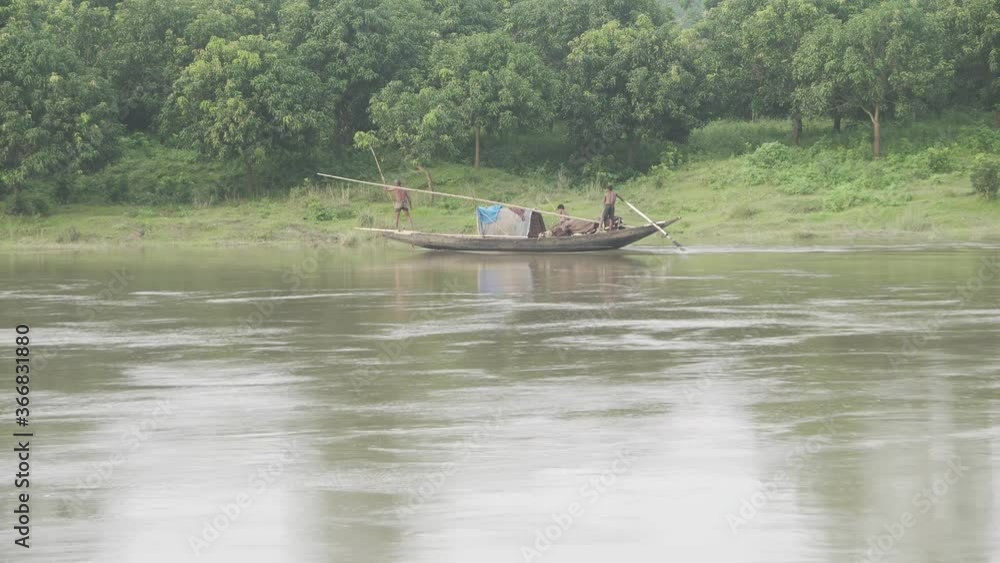 A boat is passing by a mango forest through the river stream. A boat is passing by a mango forest through the river stream.