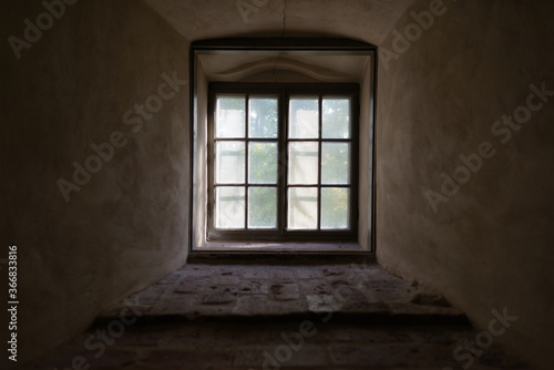 Closed vintage window cemented on brick wall with natural view and sunlight streaming in
