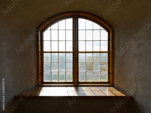 Closed wooden vintage window cemented on brick wall with natural view and sunlight streaming in