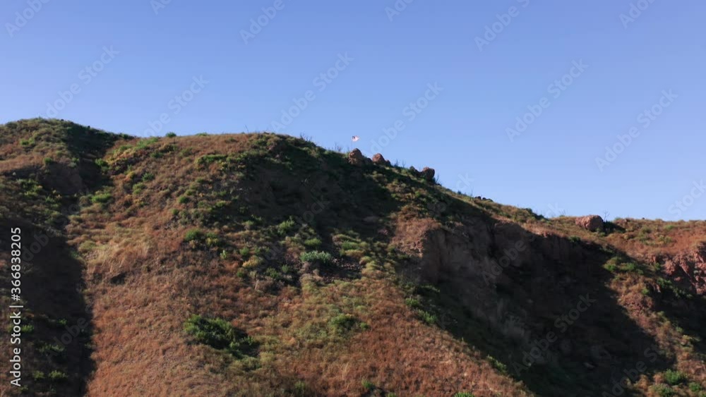 California mountains on sunny summer day. Beautiful nature of Santa Monica Mountains, Malibu, Los Angeles suburban area USA. Rocky hills with blue sky above. Beautiful drone flight above hiking trail California mountains on sunny summer day. Beautiful nature of Santa Monica Mountains, Malibu, Los Angeles suburban area USA. Rocky hills with blue sky above. Beautiful drone flight above hiking trail