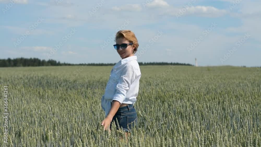 stylish young girl in denim shorts and sunglasses walks on a summer day in a wheat field hd stylish young girl in denim shorts and sunglasses walks on a summer day in a wheat field hd