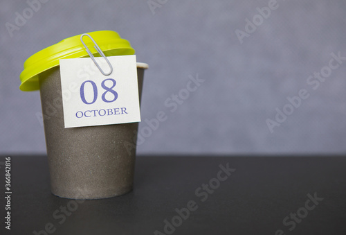 Coffee paper cup with calendar dates for October 08, fall season. Time for relaxing breaks and vacations.