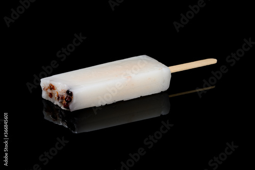 popsicle with red bean inside with couple of bites on black background