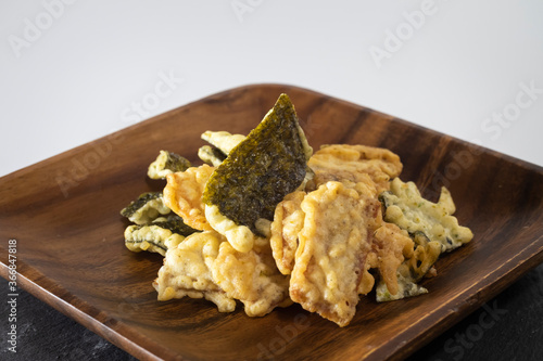 Japanese convenience store snack of fried seaweed and tempura in a wooden plate. photo