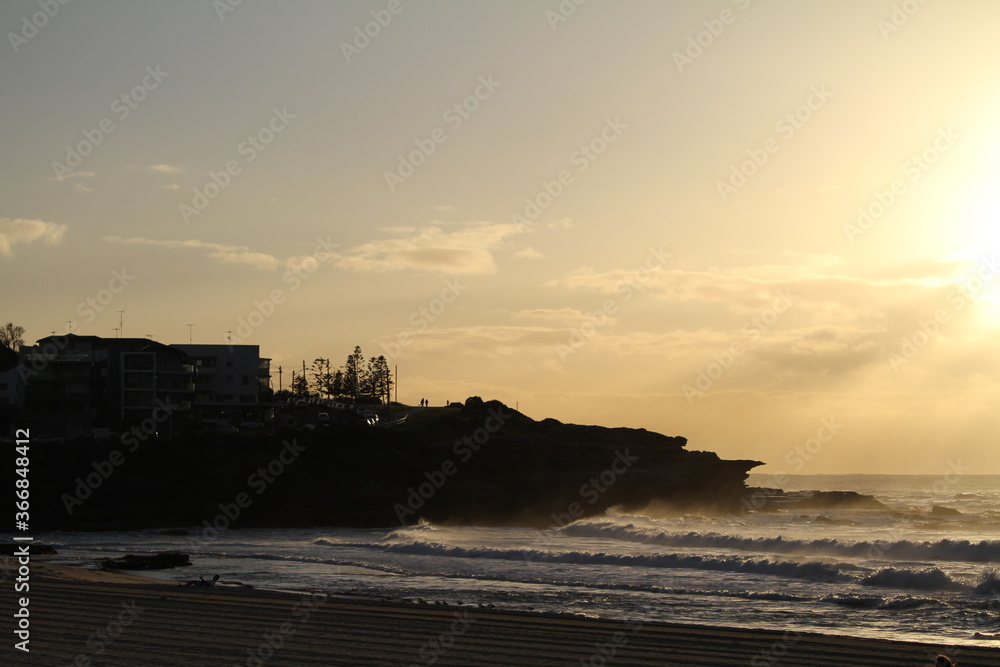 waves breaking at sunrise against the coastal cliffs 