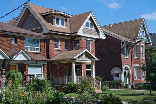Residential street with large detached brick houses and front yards