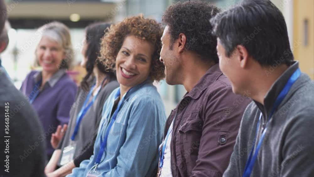Group of casually dressed businessmen and businesswomen laughing and applauding presentation at conference - shot in slow motion Group of casually dressed businessmen and businesswomen laughing and applauding presentation at conference - shot in slow motion
