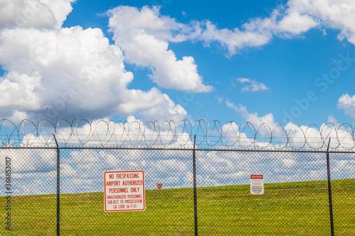 warning signs on a fence with razor wire