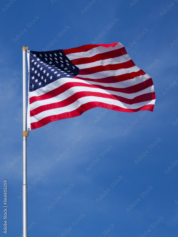 US flag waving against a blue sky