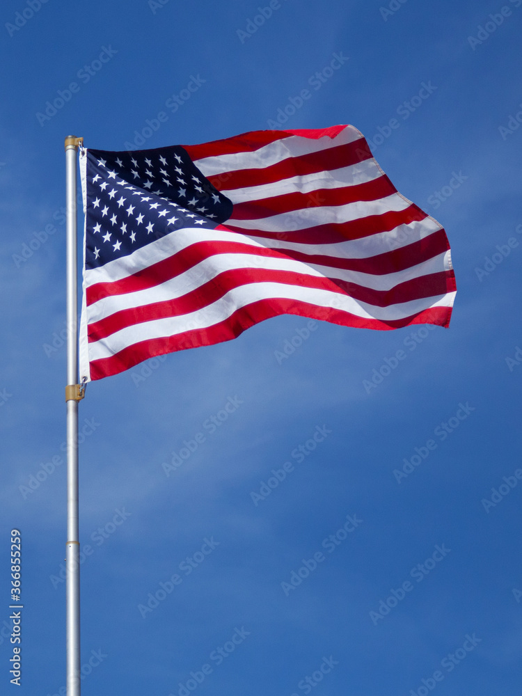 Fototapeta premium US flag waving against a blue sky