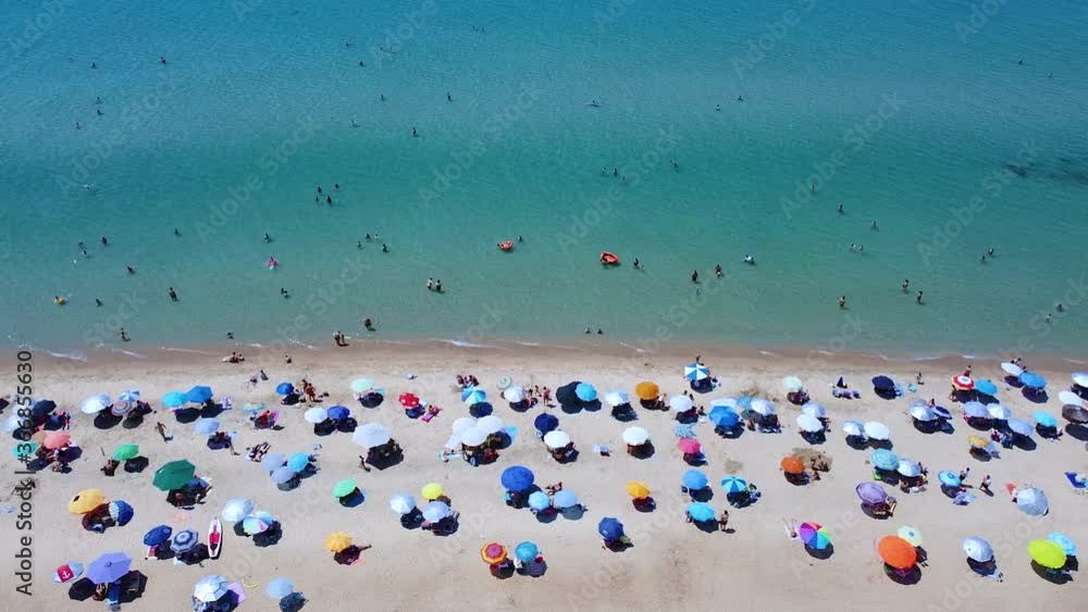 Busy weekend day on the beach. sandy beach full with tourists enjoying the sun and sea. Aerial view Busy weekend day on the beach. sandy beach full with tourists enjoying the sun and sea. Aerial view