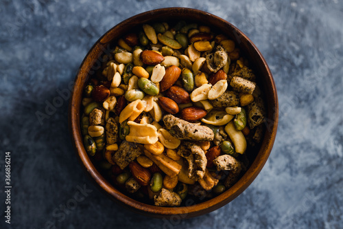 plant-based food, vegan nuts and legumes snack mix in wooden bowl