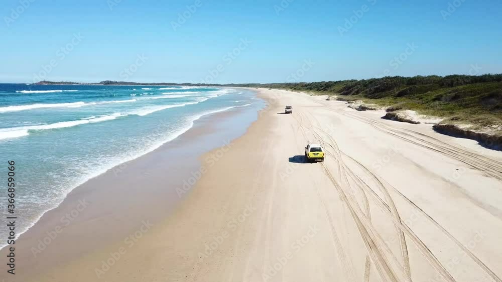 Aerial Drone Of 4x4 Cars Driving On Sandy Island Beach Beside Blue Ocean Waves In Australia Aerial Drone Of 4x4 Cars Driving On Sandy Island Beach Beside Blue Ocean Waves In Australia