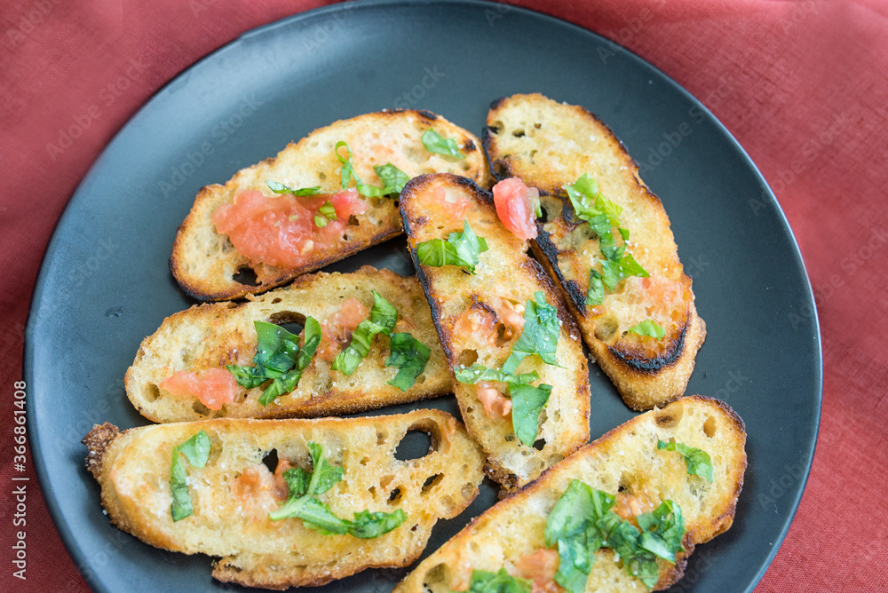 Sourdough bread fried in garlic and olive oil with squeezed tomato and chopped basil on top.
