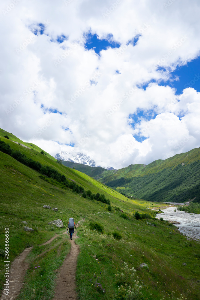 Touristic hiking trails through the green mountains, snowy peaks and rivers in Georgia