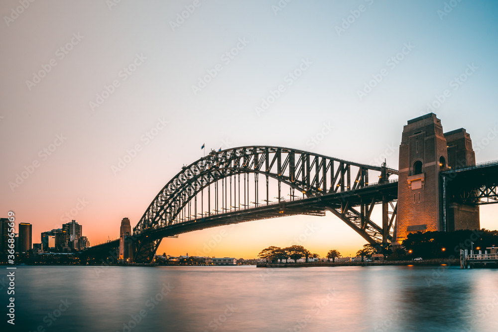 Obraz premium Beautiful sunset view of iconic sydney harbour bridge from north sydney side when the sun goes down and the sky light up in australia