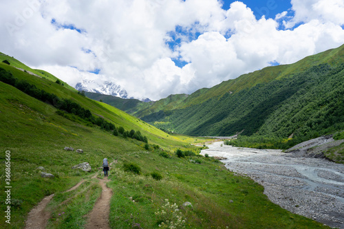 Touristic hiking trails through the green mountains, snowy peaks and rivers in Georgia