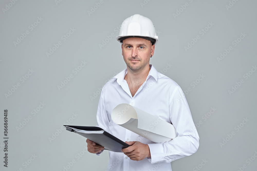 adult male in a White construction helmet. keeps the project in hand. adult male in a White construction helmet. keeps the project in hand.