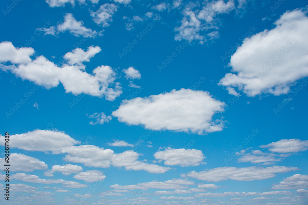 Bright blue sky with white clouds. Photographed on a sunny summer day.