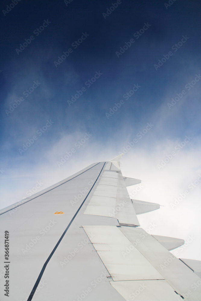 Dramatic cloudscape with the airplane's wing from the airplane's window Dramatic cloudscape with the airplane's wing from the airplane's window