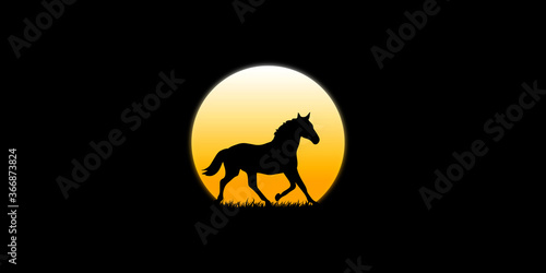 The horse walks in the dark moonlight at dusk