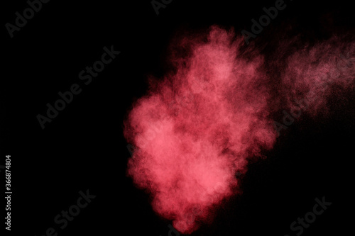 Red and pink powder explosion on black background. Colored powder cloud. Colorful dust explode. Paint Holi