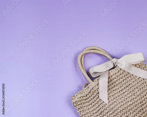 Travel accessories , summer , fashion concept.Brown woven bag on purple background