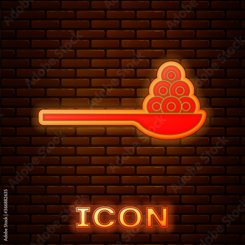 Glowing neon Caviar on a spoon icon isolated on brick wall background. Vector..