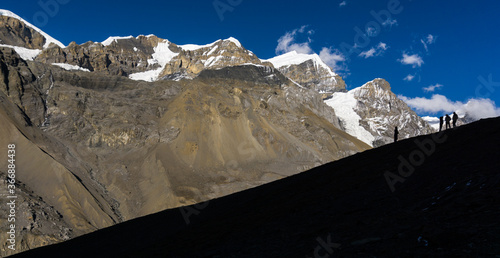 Trekkers silhouetted against a mountain near the high camp, last stop before crossing Thorong La pass (5416 m) in Annapurna Circuit trekking trail in Nepal. 