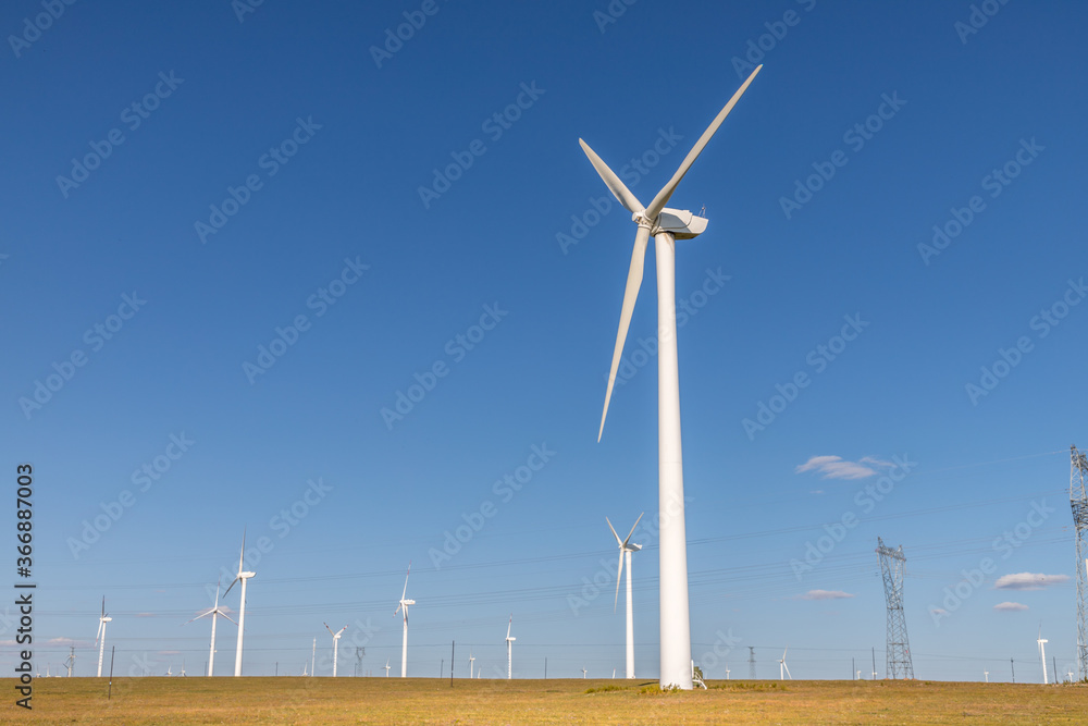 wind turbine, or wind energy converter, converts the wind's kinetic energy into electrical energy in Huanghuagou Huitengxile near Hohhot, Inner Mongolia, China, with horse, clouds and blue sky wind turbine, or wind energy converter, converts the wind's kinetic energy into electrical energy in Huanghuagou Huitengxile near Hohhot, Inner Mongolia, China, with horse, clouds and blue sky