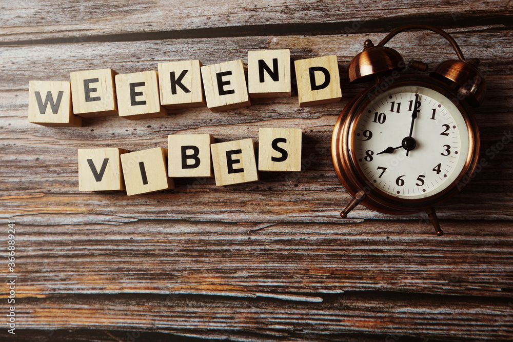 Weekend Vibes alphabet letter with alarm clock on wooden background; Weekend Vibes alphabet letter with alarm clock on wooden background;