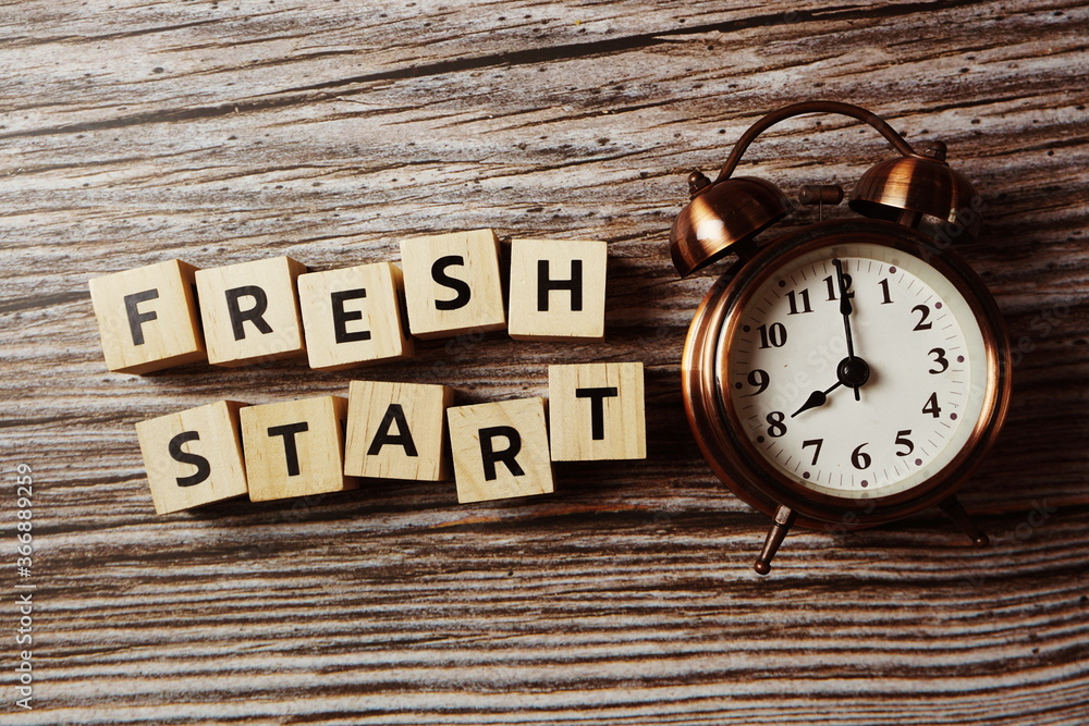 Fresh Start alphabet letter with alarm clock on wooden background; Fresh Start alphabet letter with alarm clock on wooden background;