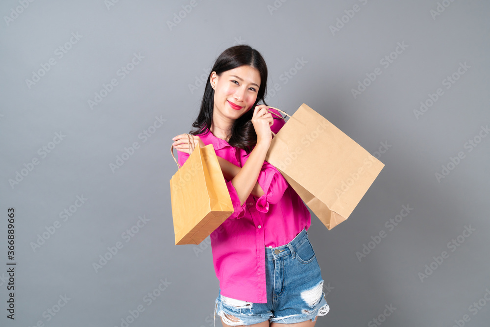 Young asian woman happy smiling and joyful holding shopping bags Young asian woman happy smiling and joyful holding shopping bags