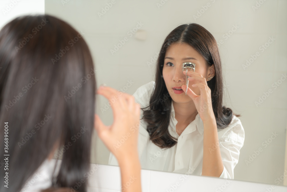 Asian woman make up herself looking mirror