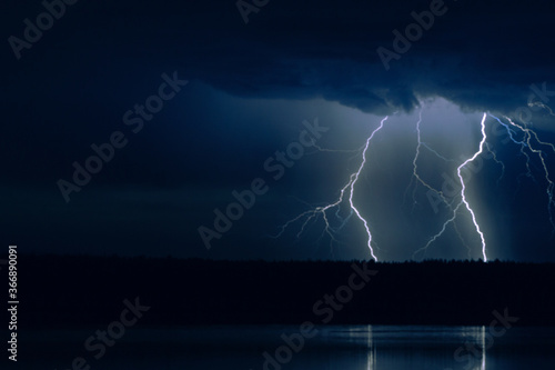 several lightning strikes during a strong thunderstorm over the lake