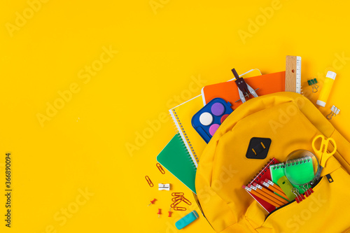 School backpack isolated on yellow background.