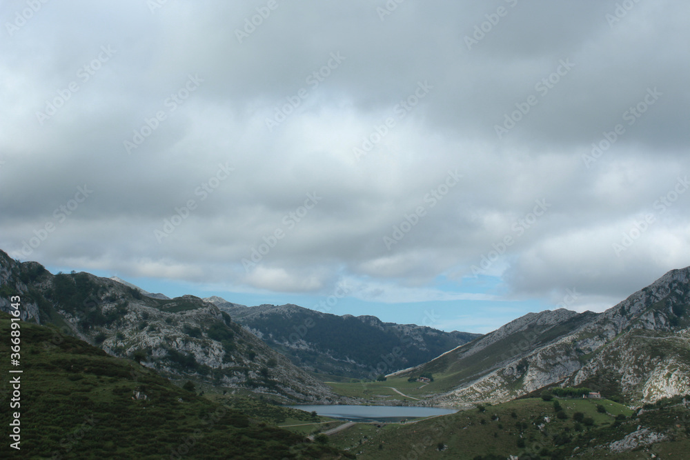 A mountain with a lake and clouds in the background (Peaks of Europe, Asturias, Spain)
